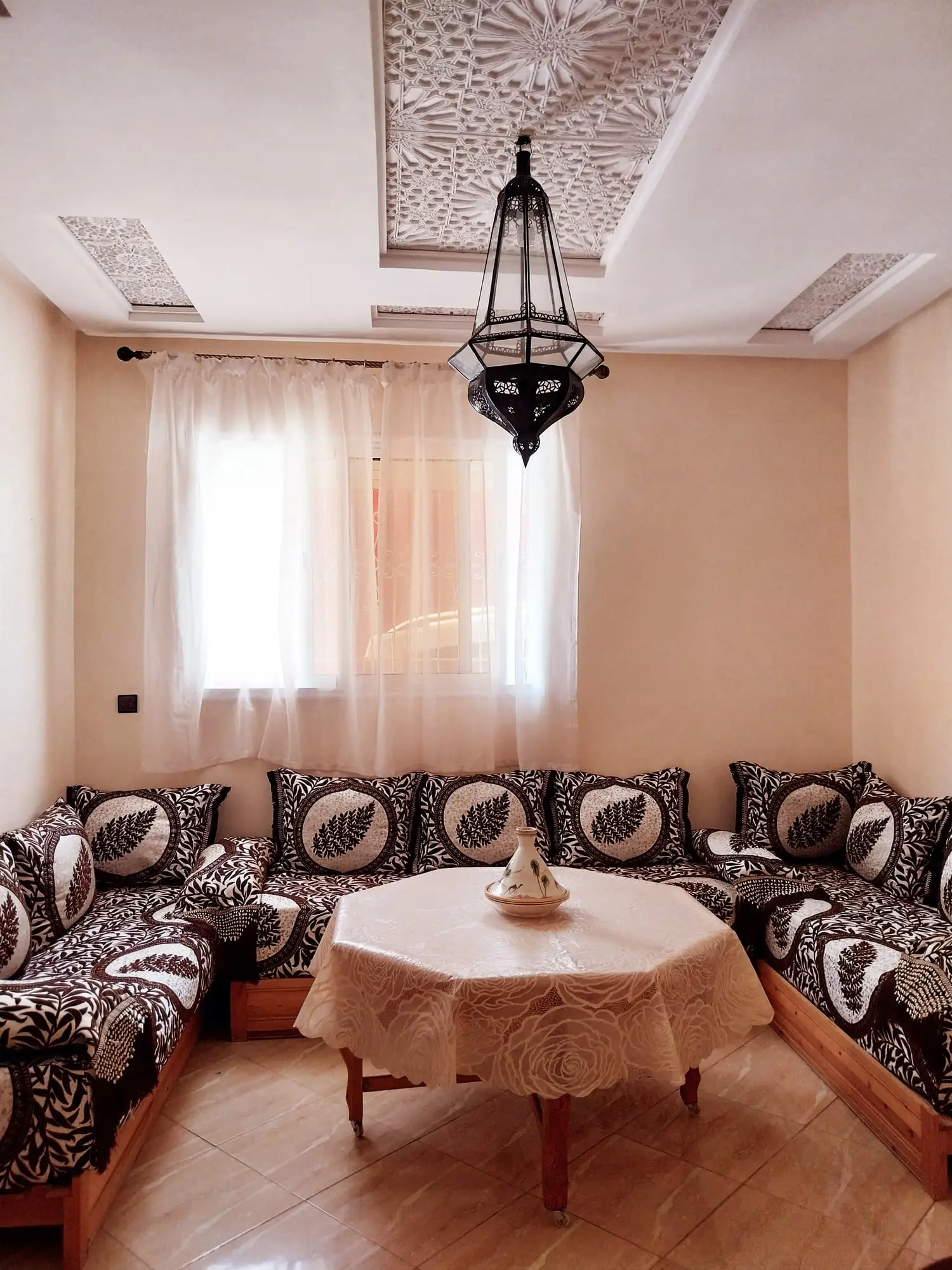 Living room seating around an octagonal table beneath the carved ceiling