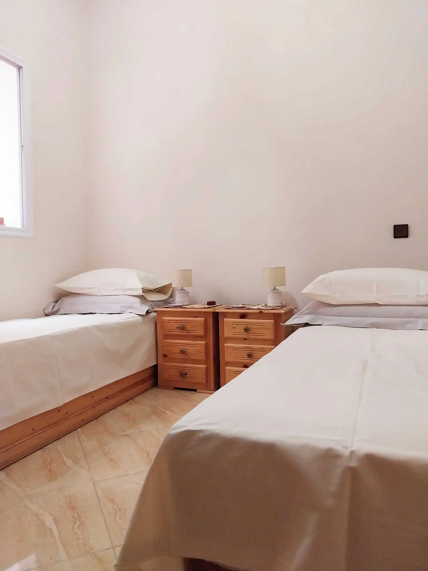Twin bedroom with the beds made up in white linen