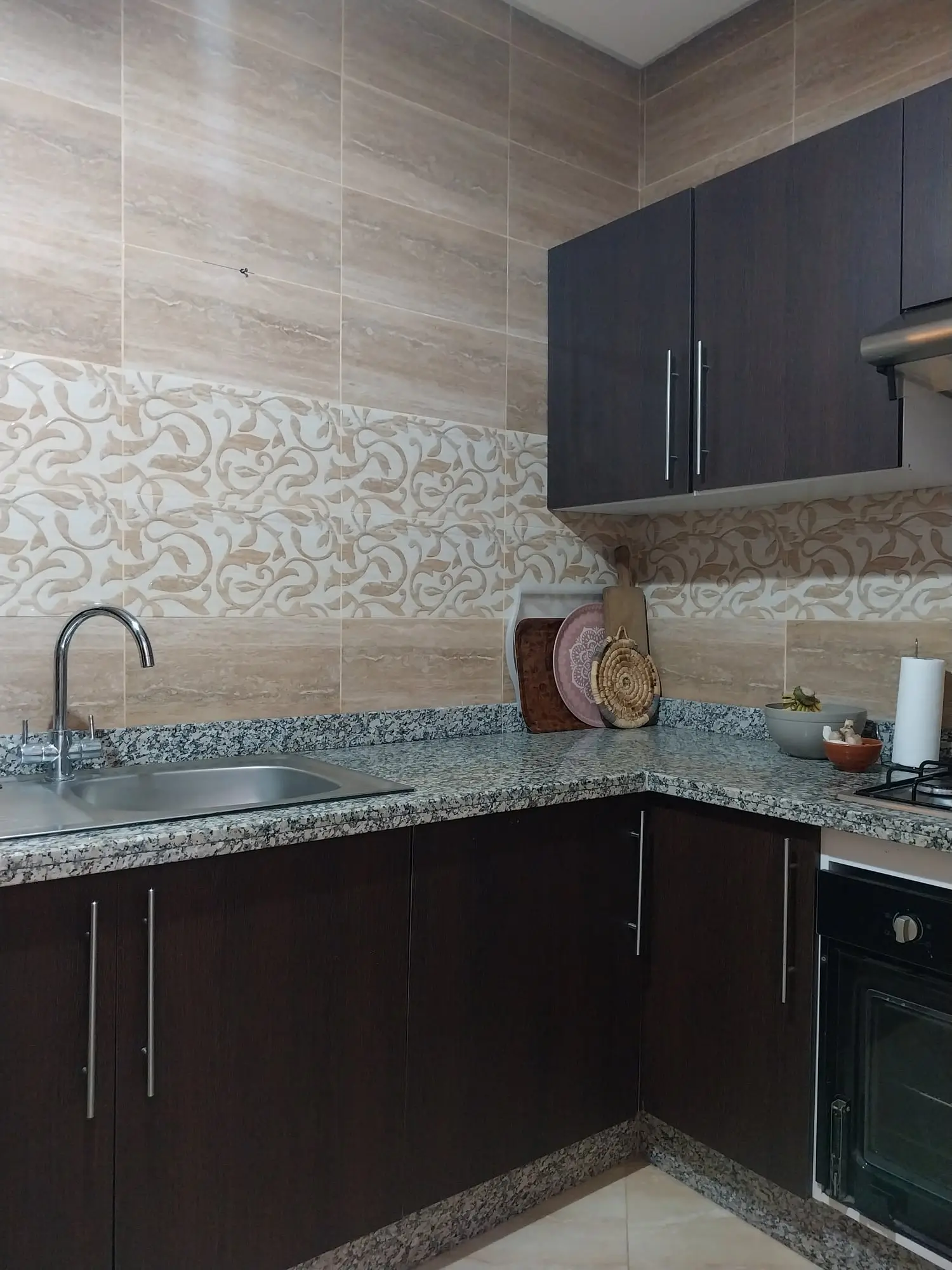 Kitchen with dark cabinets, granite worktops and an oven
