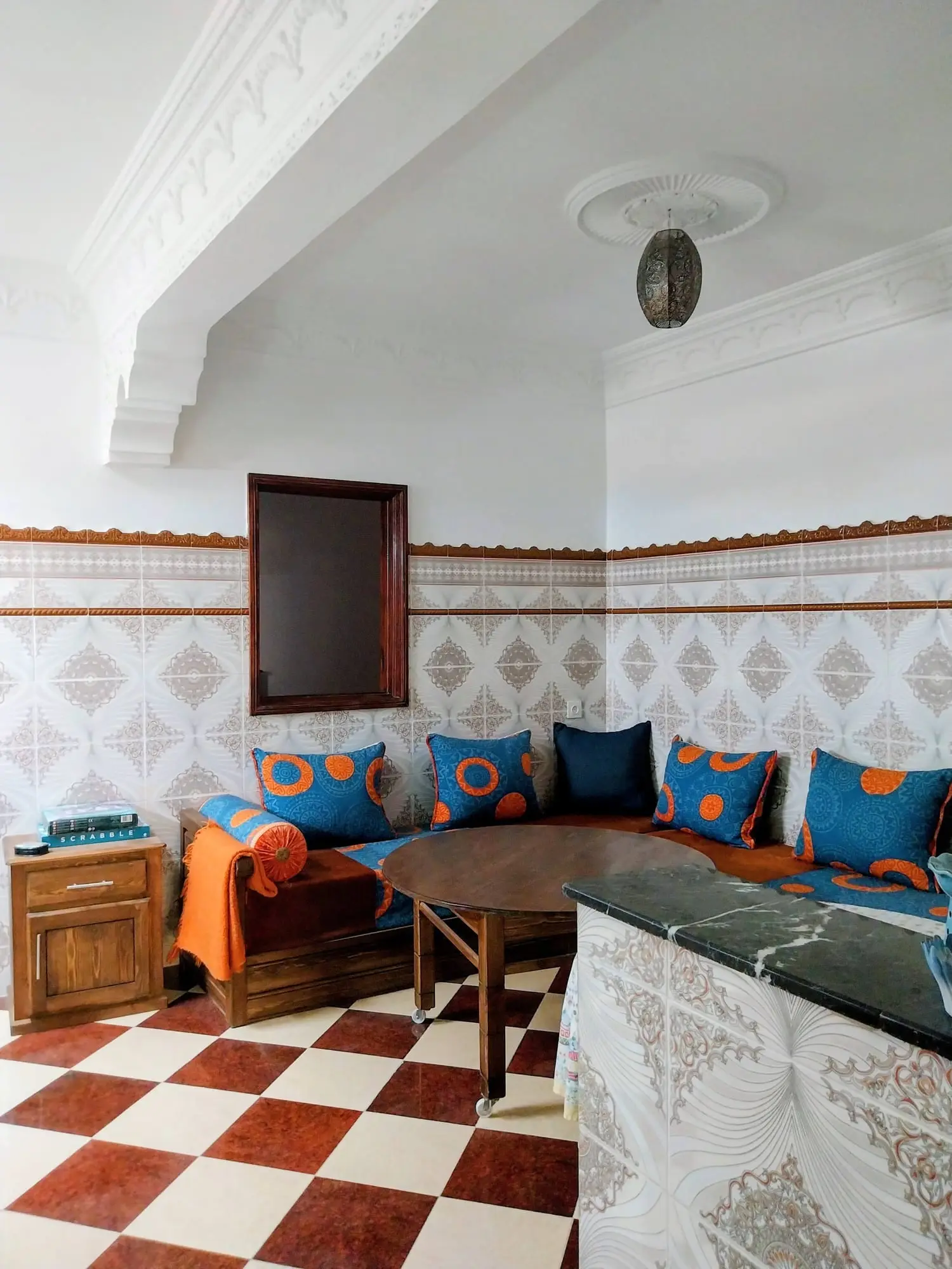 Salon banquettes and a wooden table beneath a carved ceiling