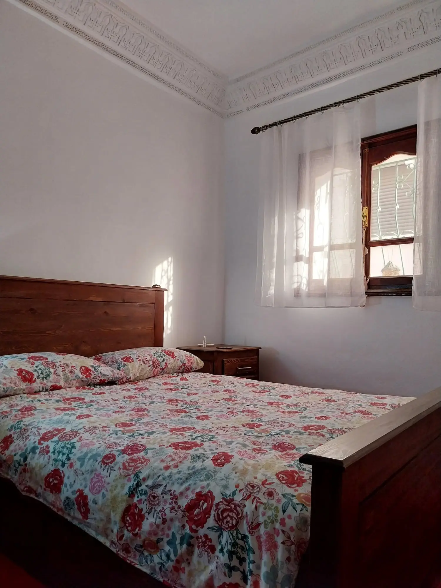 Double bedroom with a wooden bed and a floral bedspread