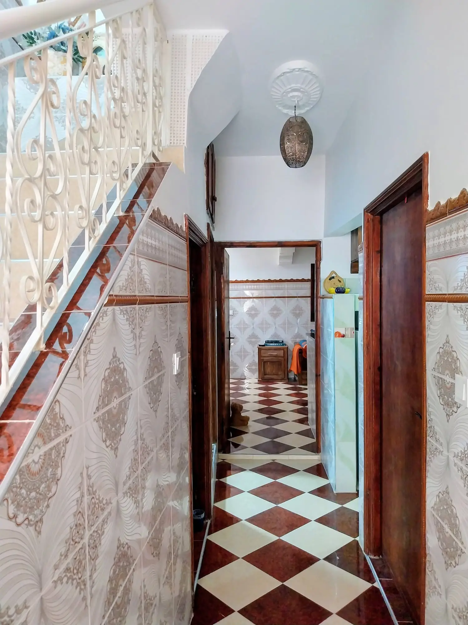Hallway with a checkerboard floor beside the staircase