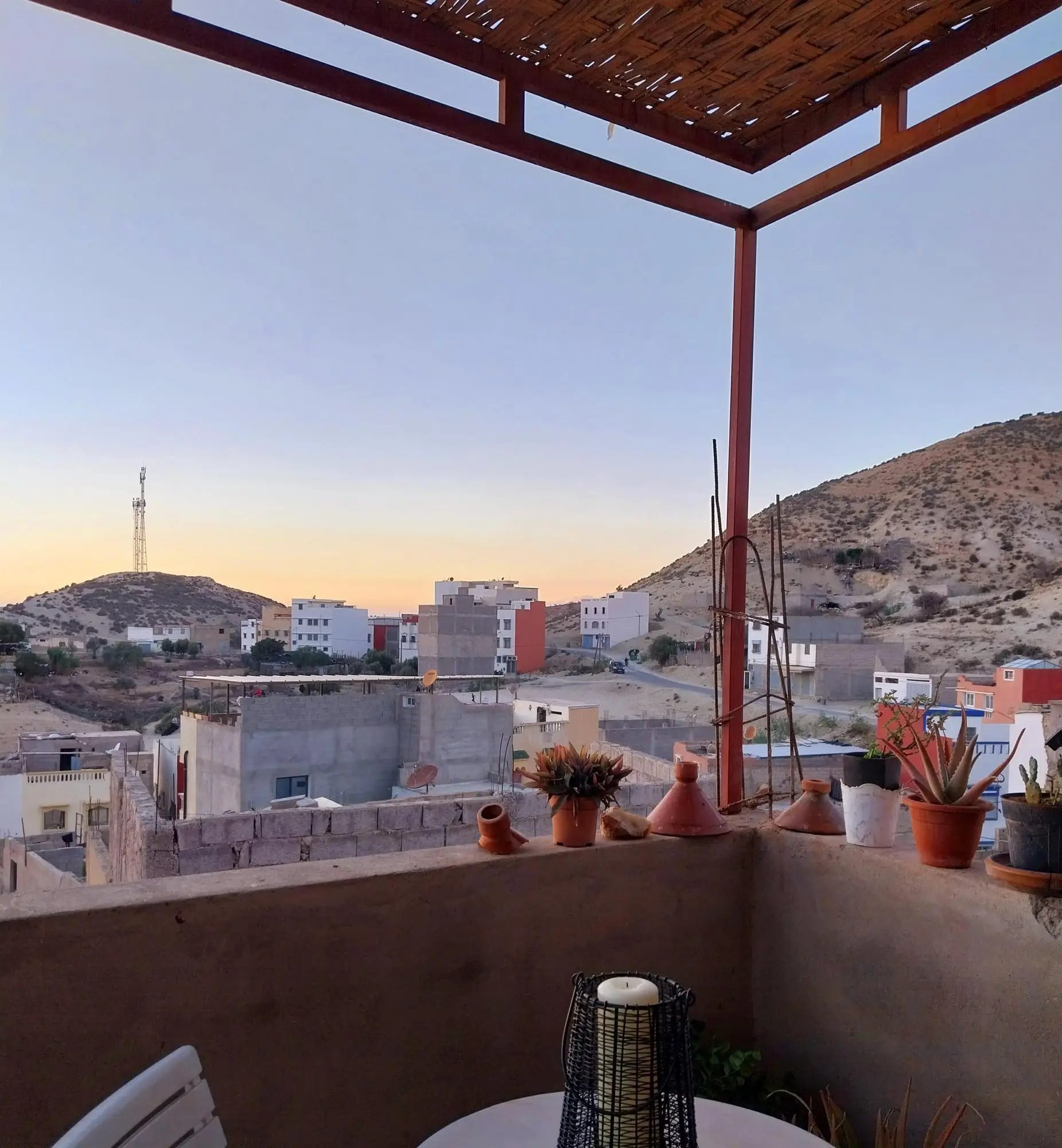 Terrace corner with potted plants, overlooking Aourir and the hills
